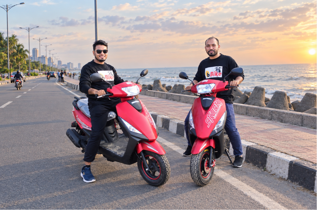 Two riders on a scooter along a coastal road