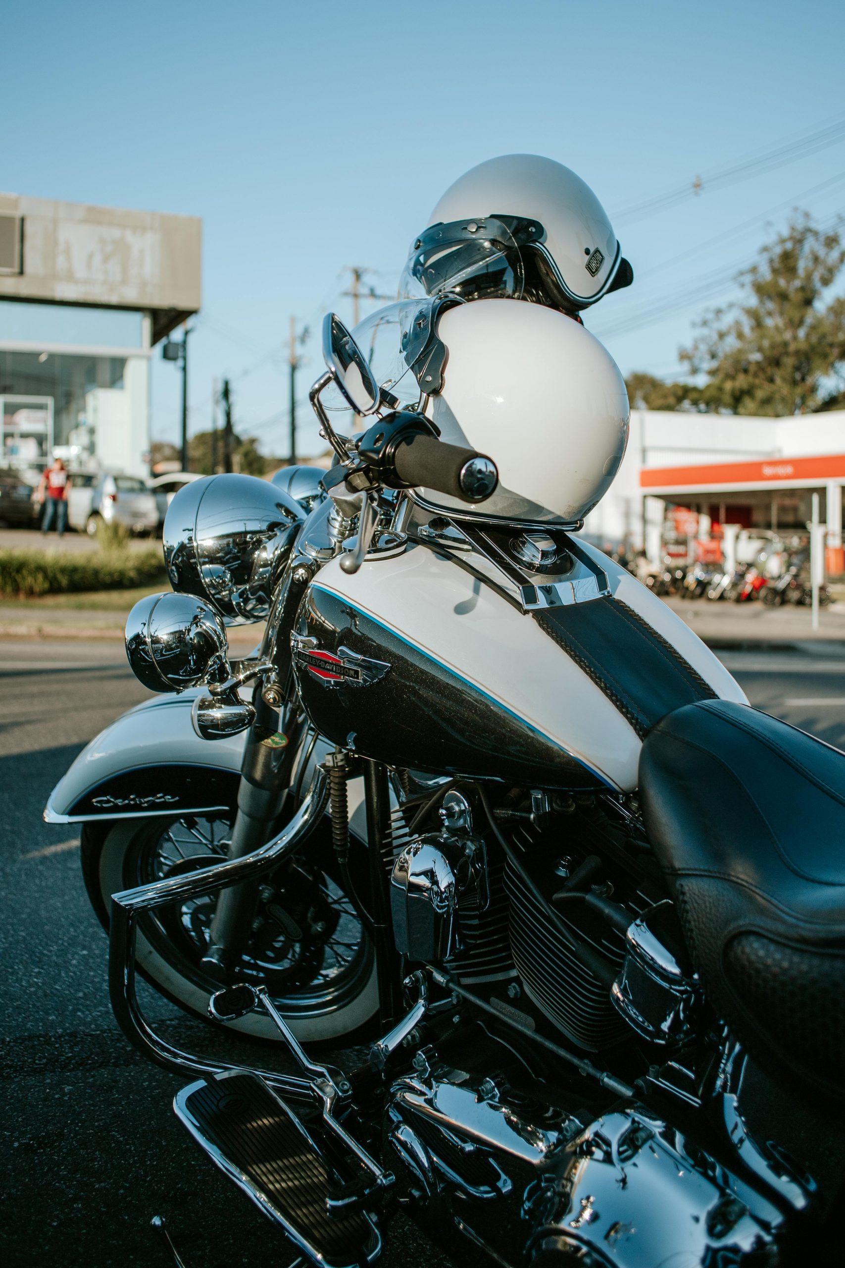 Close-up of a Harley Davidson motorcycle with helmets in a city street scene.